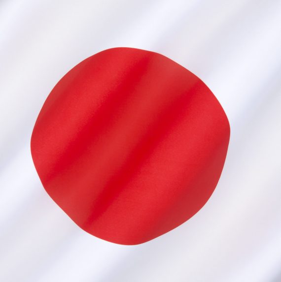 The national flag of Japan - a white rectangular flag with a large red disc (representing the sun) in the center. This flag is officially called Nisshoki in Japanese, but is more commonly known as Hinomaru.
